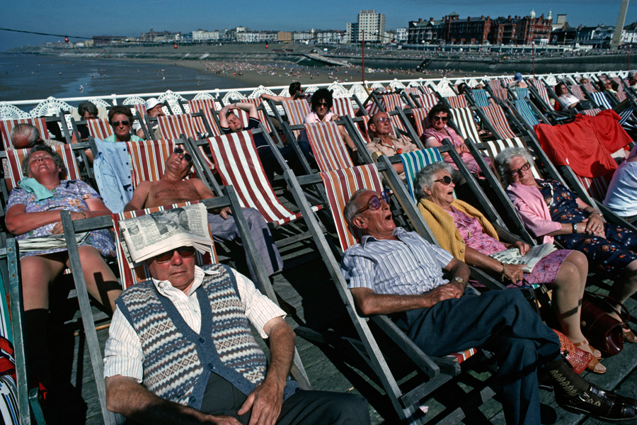 Urlauber am August-Feiertag sonnen sich 1981 in Liegestühlen auf dem Blackpool North Pier in Lancashire, England, Vereinigtes Königreich