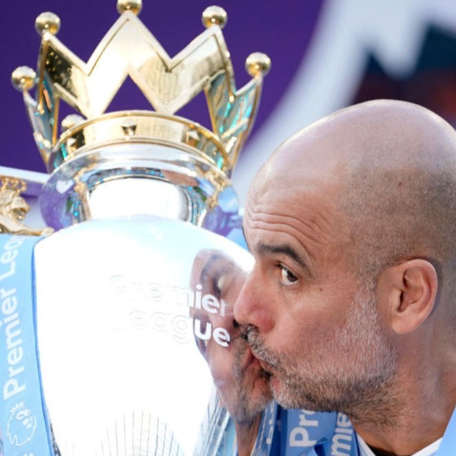 Manchester City's head coach Pep Guardiola celebrates with the Premier League trophy after the English Premier League soccer match