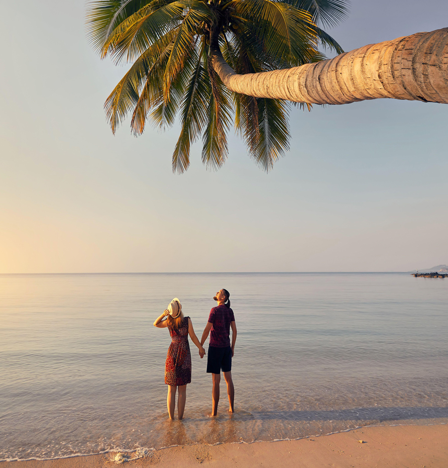 Ein glückliches Paar als Silhouette am tropischen Strand in der Nähe einer Palme auf der Insel Phi Phi in Südthailand