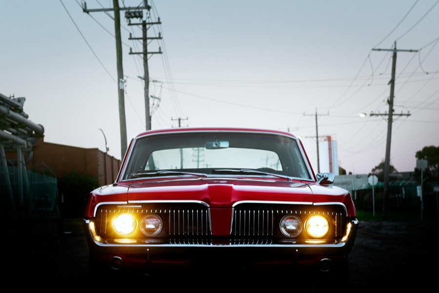 Image graphique d'une voiture de muscle rouge classique vintage de l'avant avec des phares isolés avec de la place pour la copie