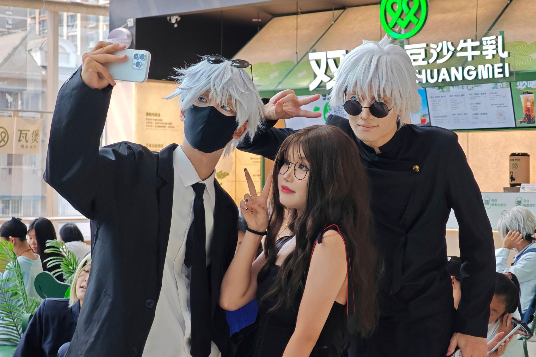 A woman poses for photos with two cosplayers in a shopping mall in Shanghai, China Monday, Aug. 26, 2024. (FeatureChina via AP Images) - Image ID: 2XXRWN2 (RM)