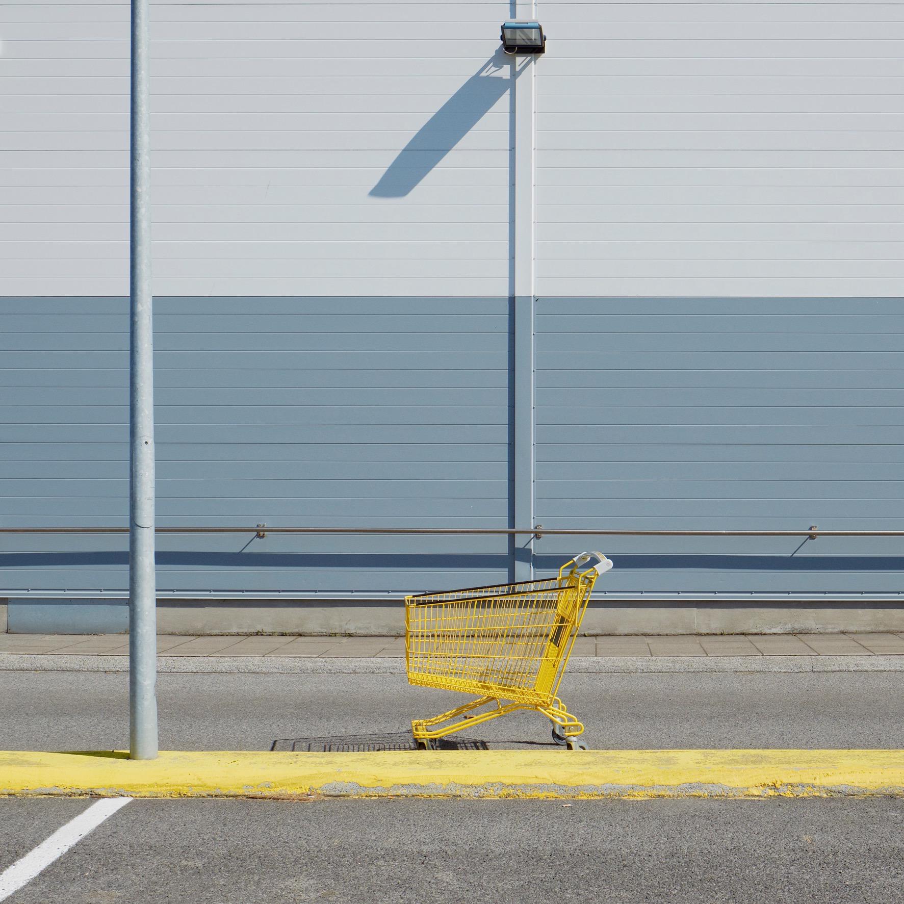 Yellow shopping trolley in an empty car park