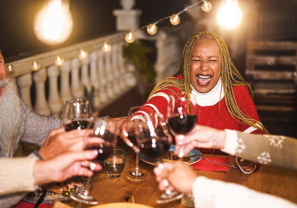 Multiracial senior people celebrate new year's eve together doing dinner outdoor - Holidays concept - Soft focus on african woman face 