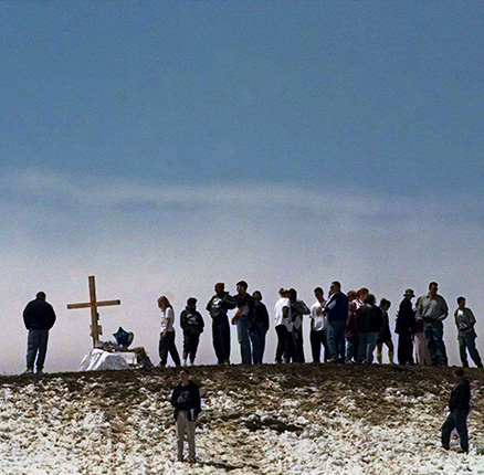 In this Saturday, April 24, 1999 file photo, mourners gather on top of a hill overlooking Columbine High School in Littleton, Colo. A total of 15 people, including gunmen Eric Harris and Dylan Klebold, died in the attack at the school. 